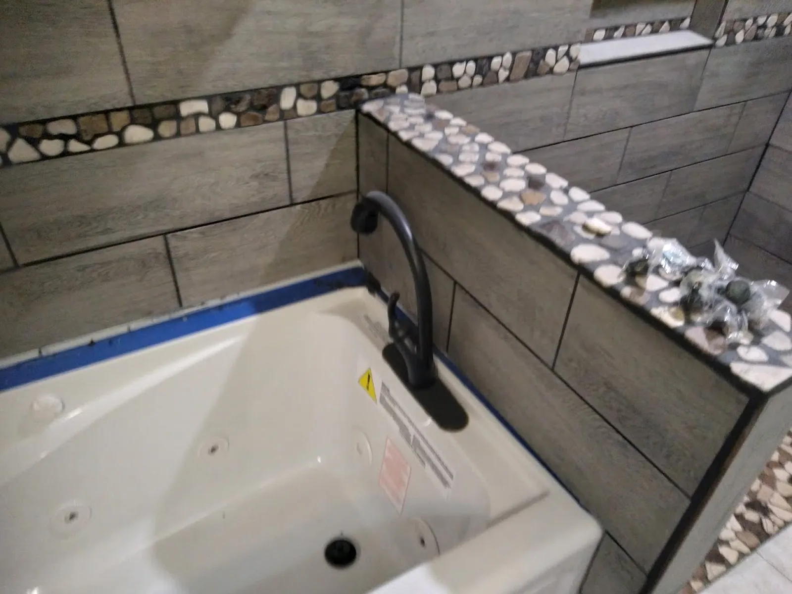 Bathroom tub surround with tile and stone accent detail